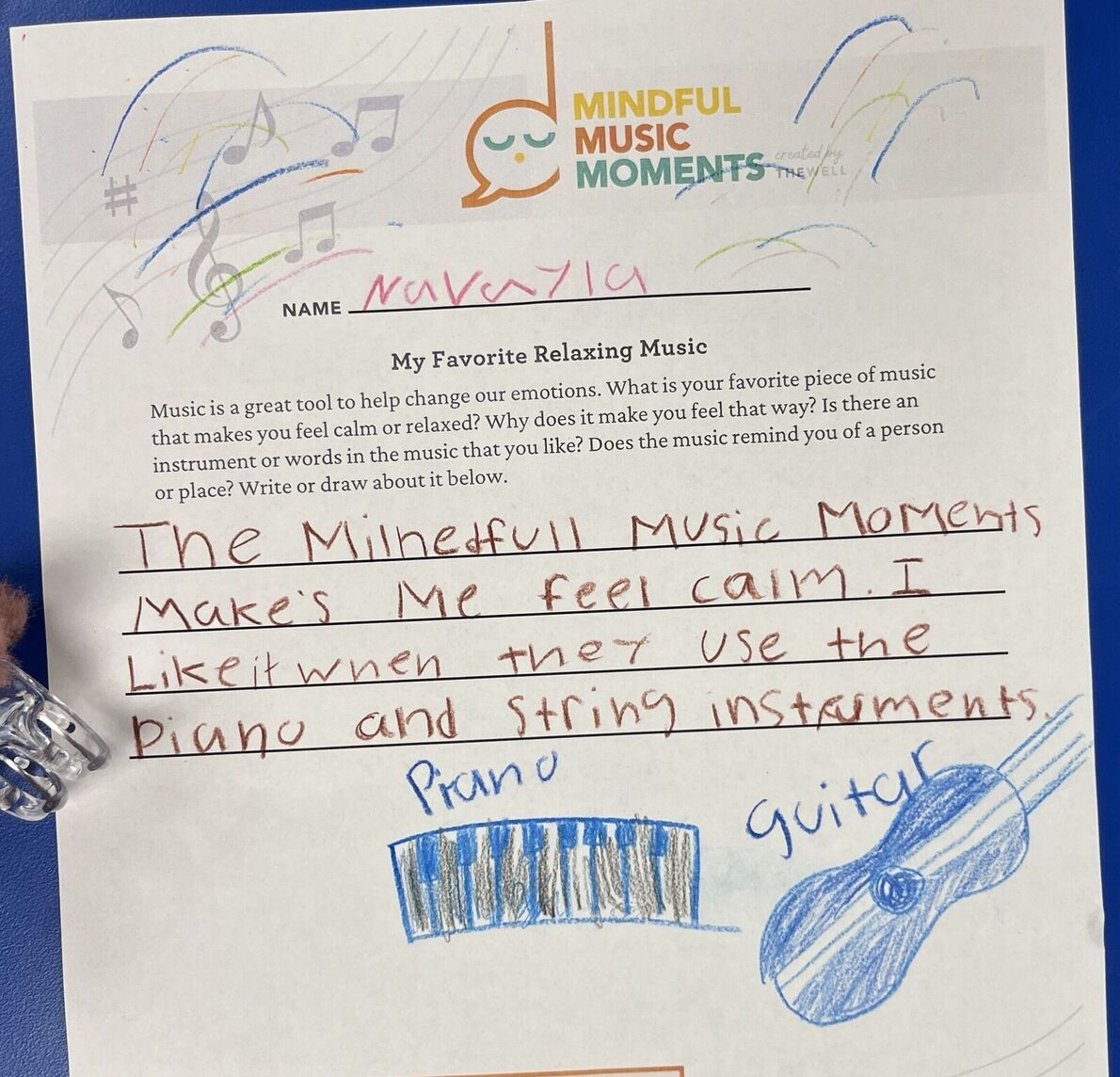 A worksheet with a drawing of a piano and guitar. Student wrote